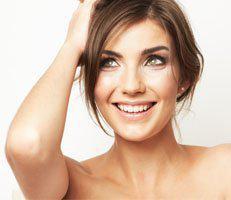 Woman smiling after hair regrowth treatment at advanced rejuvenation centers.