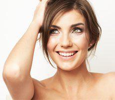 Woman smiling after hair regrowth treatment at advanced rejuvenation centers.