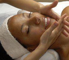 Woman smiling receiving a facial at advanced rejuvenation centers.